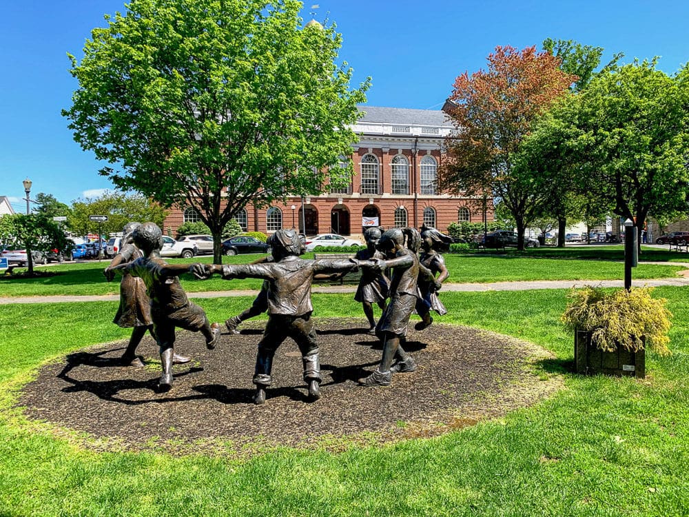 This statue of kids holding hands is located in Needham, a city Sinclaire Home Services, an hvac company, offers services to.