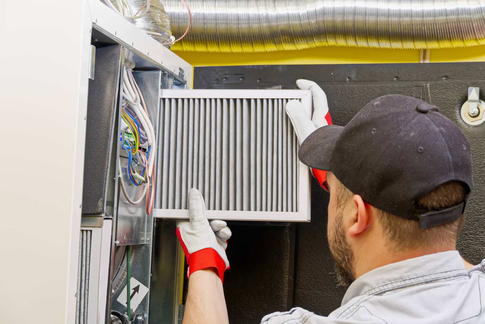 HVAC service technician changing furnace filters