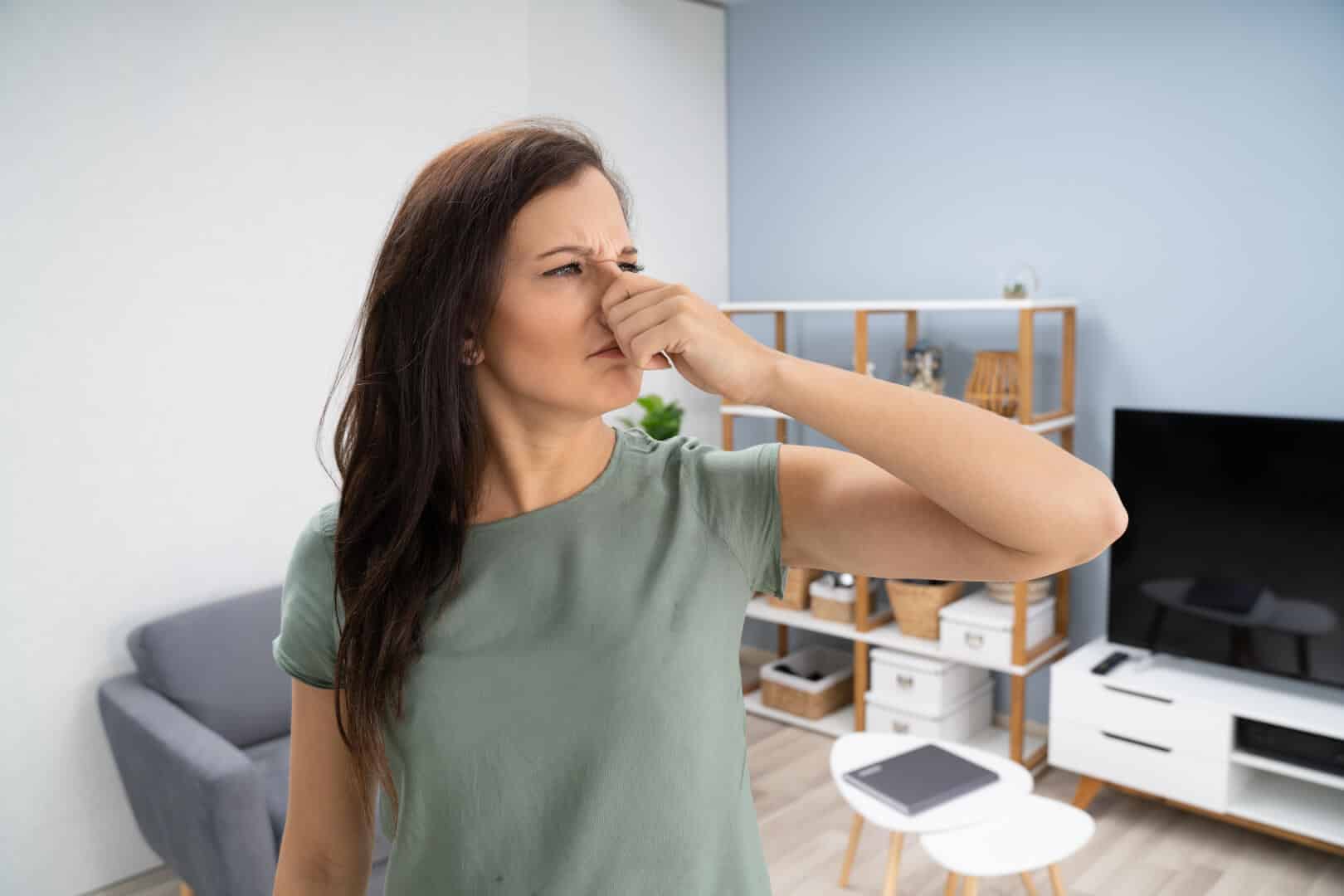 Woman Covering Her Nose From AC Musty Smell