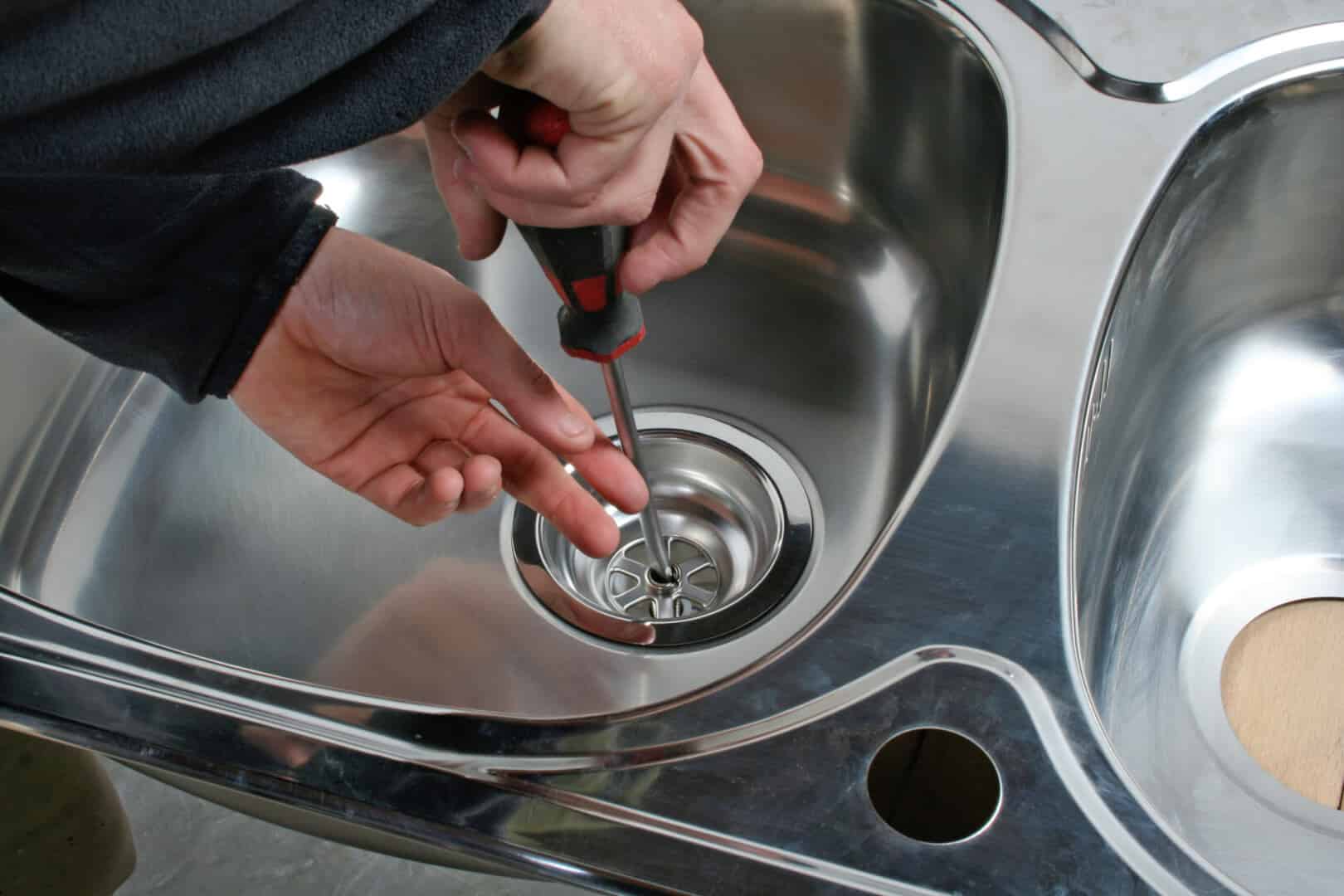 Man Repairing a Sink Drainage with a screw