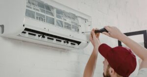 HVAC technician performing AC repair on a central air conditioning system at a Massachusetts home