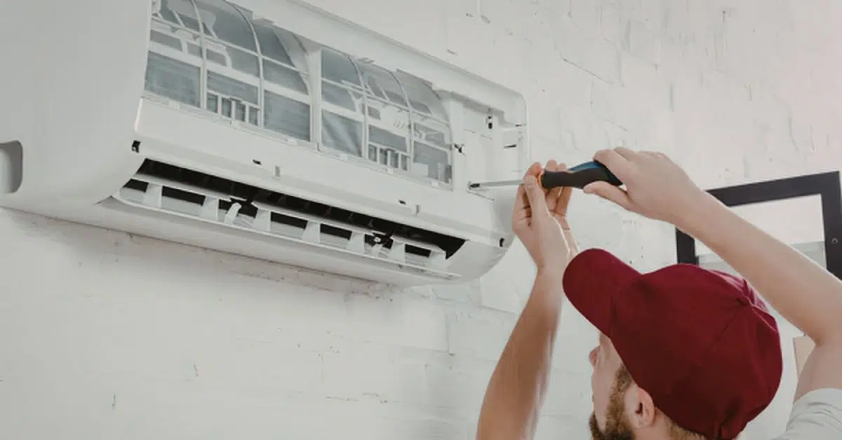 HVAC technician performing AC repair on a central air conditioning system at a Massachusetts home